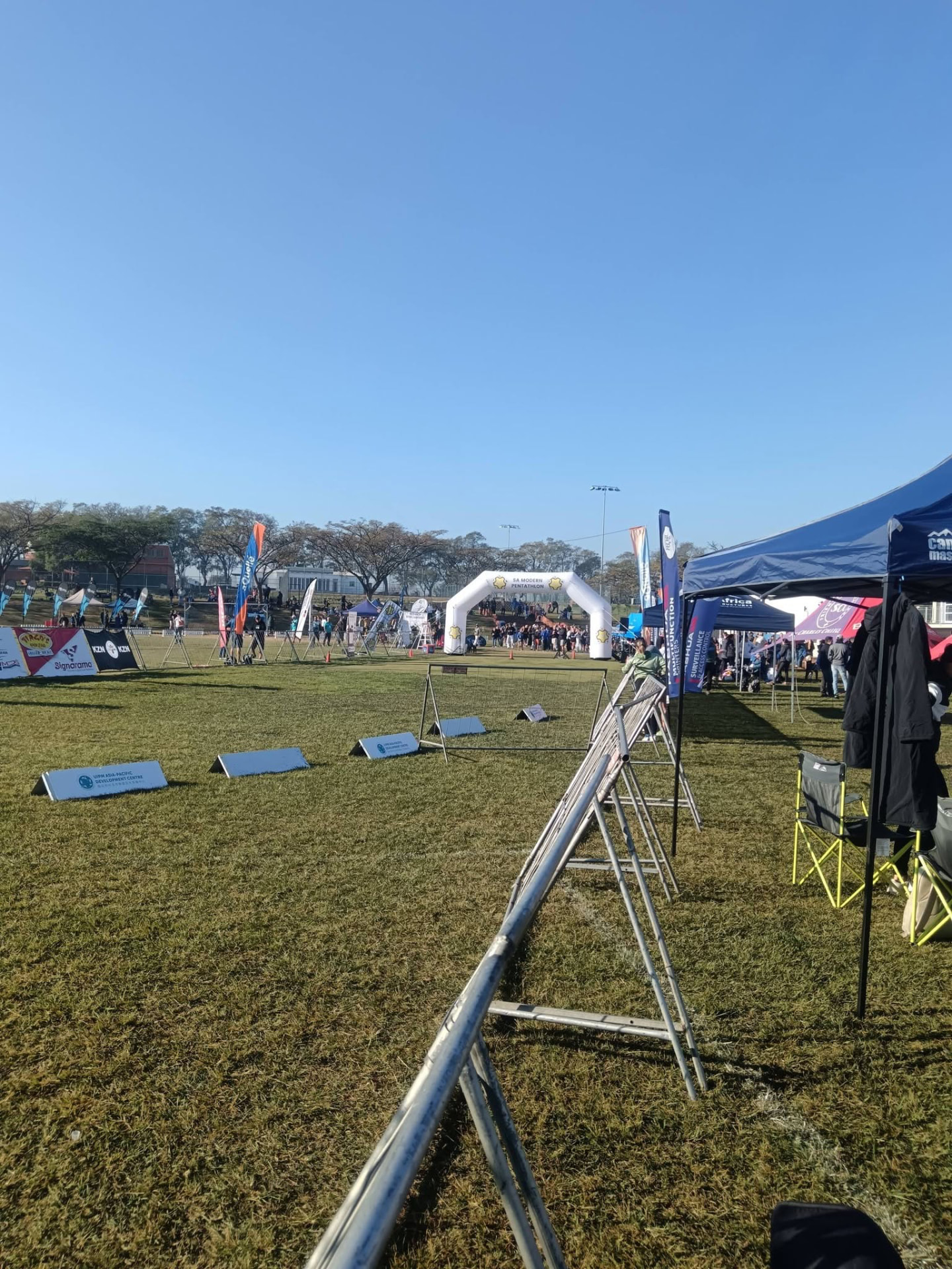 Athletes, gazebos and sponsor banners lining the laser run course at St Charles College